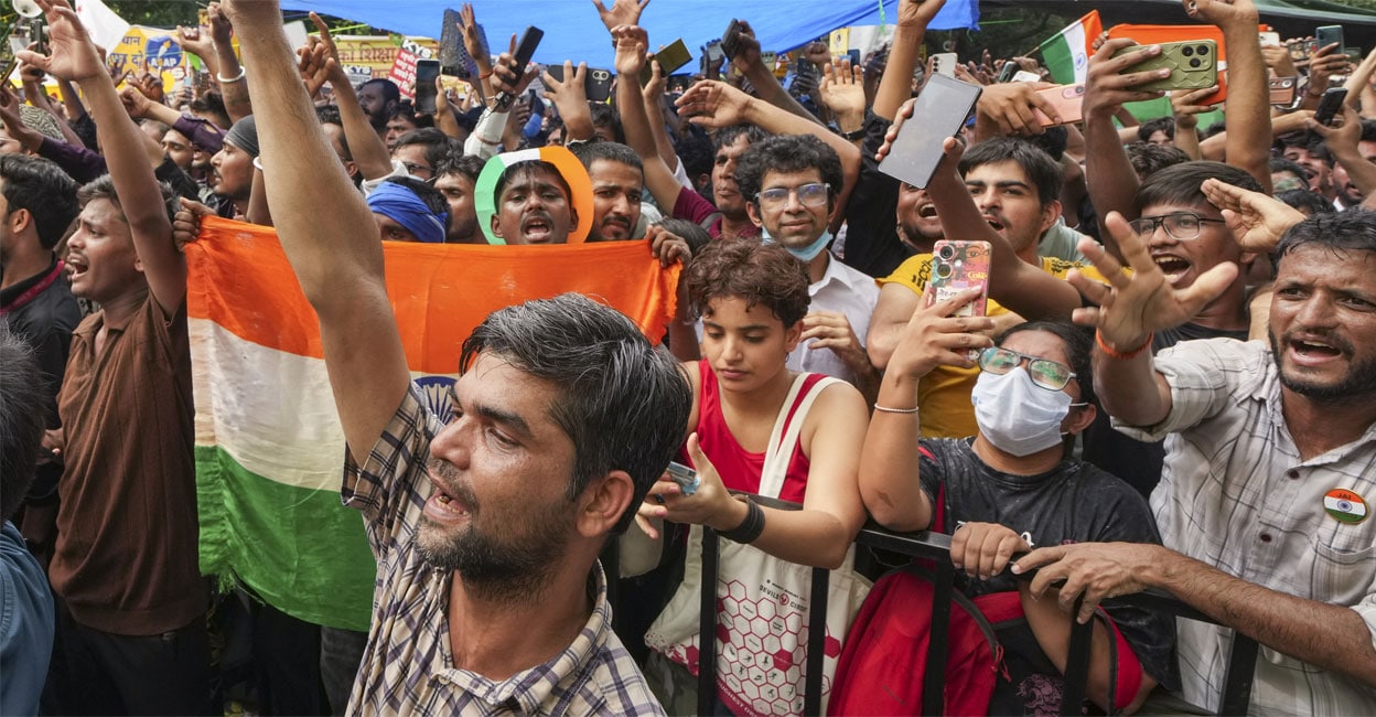 Protesters celebrating the news of Dharmendra Pradhan's resignation. Photo: PTI