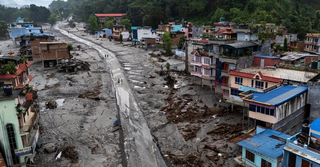 A drone view shows people walk on a road and houses covered in mud following deadly flash floods and mudslides, in Devighat, Nuwakot district, Nepal. Photo: Reuters