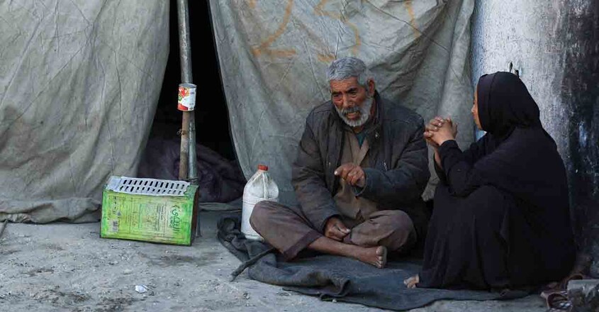 Palestinians sit next to a tent, amid a ceasefire between Israel and Hamas, in Gaza City, October 14, 2025. REUTERS/Dawoud Abu Alkas