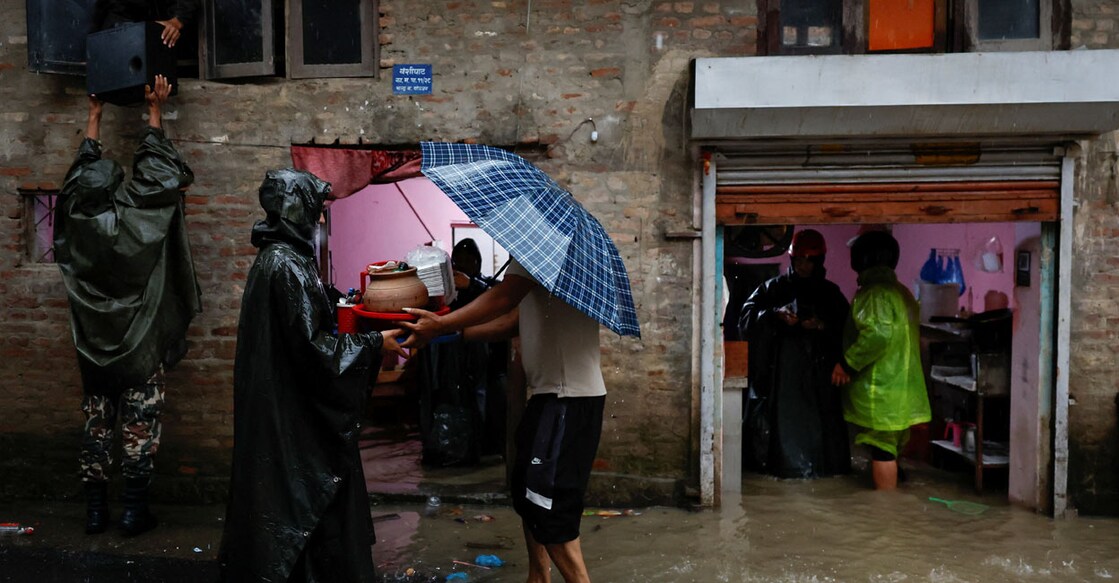 Members of the Nepal Army help people retrieve their belongings to a safe area at a flooded street along the bank of the overflowing Bagmati River. Photo: REUTERS/Navesh Chitrakar