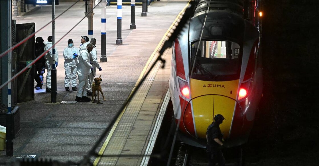 Police officers and a dog handler work on the platform alongside an LNER Azuma train at Huntingdon Station in Huntingdon. Photo: AFP