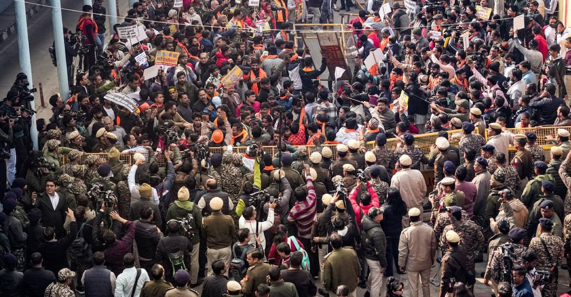 Vishwa Hindu Parishad (VHP) and Bajrang Dal members walk over barricades during a protest near the Bangladesh High Commission over attacks on Hindus in the neighbouring country, in New Delhi, Tuesday. Photo: PTI