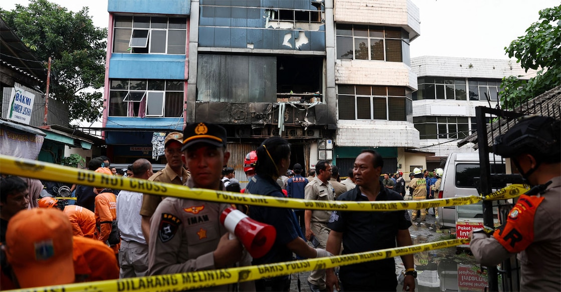 Police officers stand near a seven-storey building damaged by fire, in Jakarta, Indonesia. Photo: REUTERS/Ajeng Dinar Ulfiana