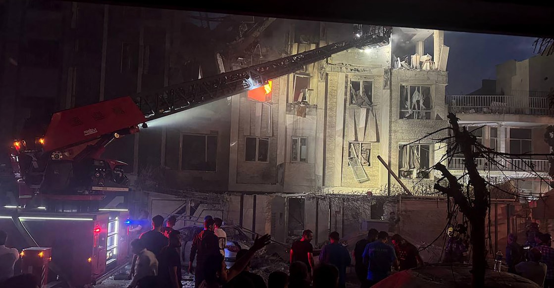 israel iran strike This handout photo released by Iran's Revolutionary Guard Corps (IRGC) official Sepah News Telegram channel on June 13, 2025 shows onlookers and rescue teams in front of a building that caught fire following and Israeli strike on the Iranian capital Tehran early in the morning. Photo: AFP PHOTO / SEPAH NEWS
