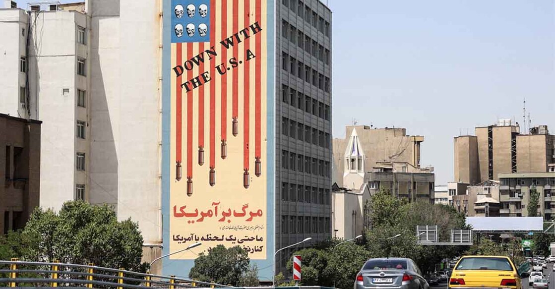 Commuters drive along a bridge near a building bearing a landmark anti-US mural in Tehran, on June 22, 2025. Photo: AFP
