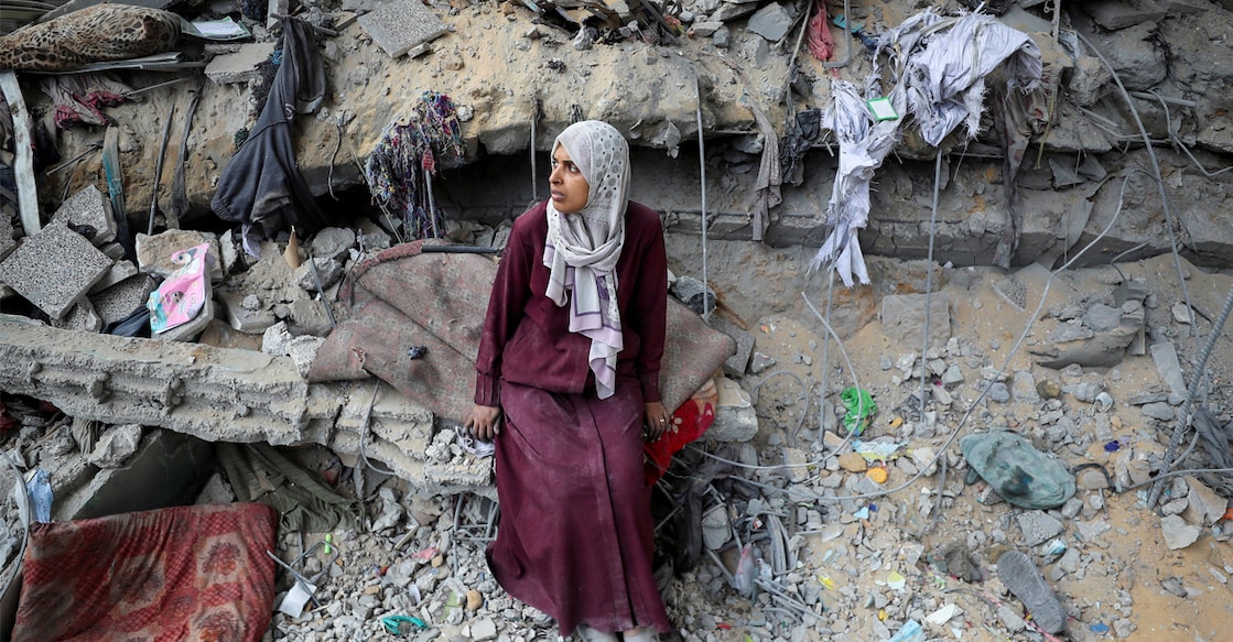israel-gaza-palestine-conflict A Palestinian woman sits amidst the damage at an UNRWA school sheltering displaced people that was hit in an Israeli air strike. Photo: REUTERS/Mahmoud Issa