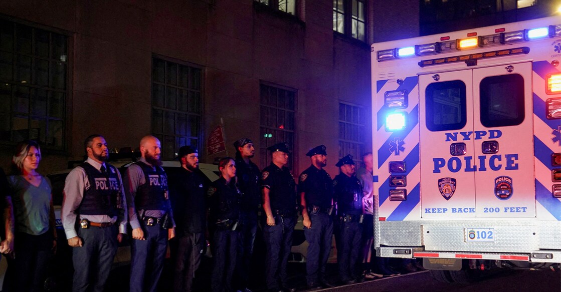NYPD officers stand at attention for the ambulance transfer of slain NYPD officer Didarul Islam, who was killed during a mass shooting in Midtown Manhattan. Photo: Reuters