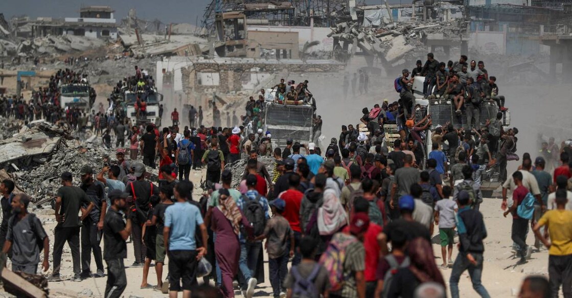 Palestinians climb onto trucks as they seek for aid supplies that entered Gaza through Israel in Beit Lahia, northern Gaza Strip. Photo: Reuters