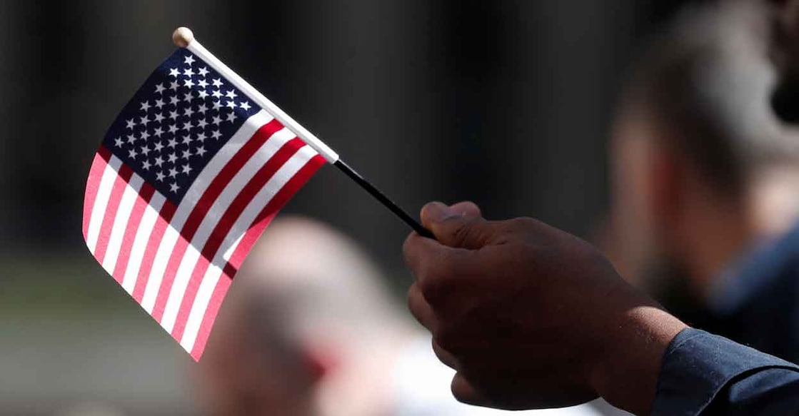 A citizenship candidate holds a flag during the U.S. Citizenship and Immigration Services (USCIS) naturalization ceremony at Rockefeller Plaza in New York City, U.S., September 17, 2019. File Photo: REUTERS/Shannon Stapleton