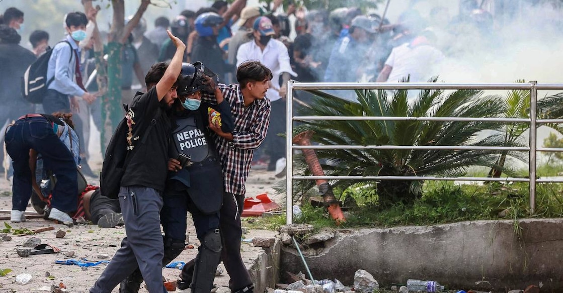 Demonstrators carry an injured police personnel during a protest outside the Parliament in Kathmandu on September 8, 2025, held to condemn the government over social media prohibitions and corruption. Photo: AFP