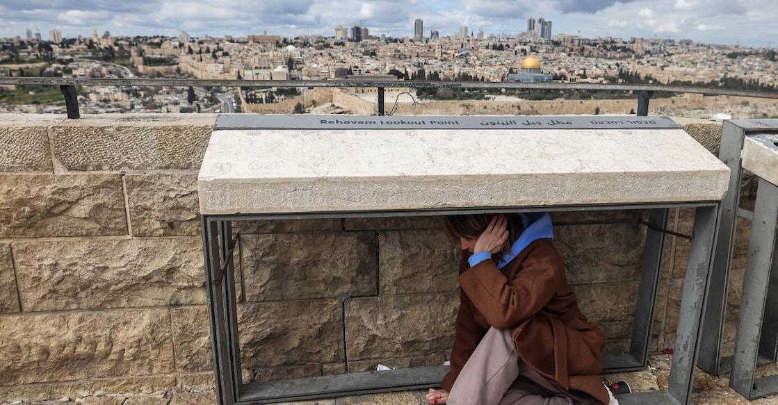 A person takes shelter as sirens sounded in Jerusalem on February 28, 2026, following the announcement that Israel had launched a “preemptive strike” on Iran. Photo: AFP