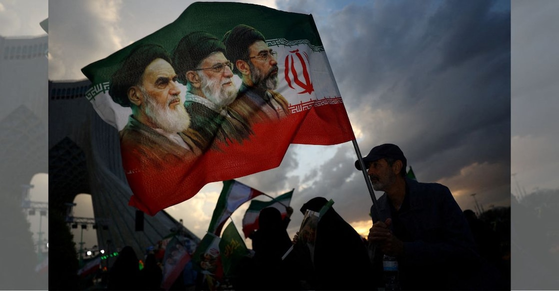 A man holds a flag during a rally in Tehran. Photo: Majid Asgaripour/WANA via Reuters