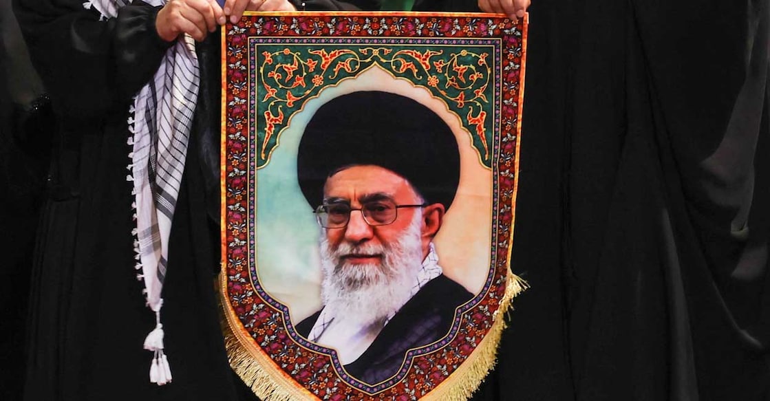 Women hold an image of Iran's late Supreme Leader Ayatollah Ali Khamenei as they walk to pay their respects near the coffins of Khamenei  at the Imam Khomeini Grand Mosalla in Tehran, Iran July 3, 2026. Photo: REUTERS/Mohammed Salem