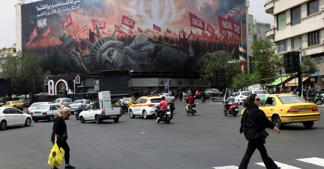 People walk past an anti-U.S. billboard on a street in Tehran, Iran in August 2026. Photo: West Asia News Agency via Reuters 