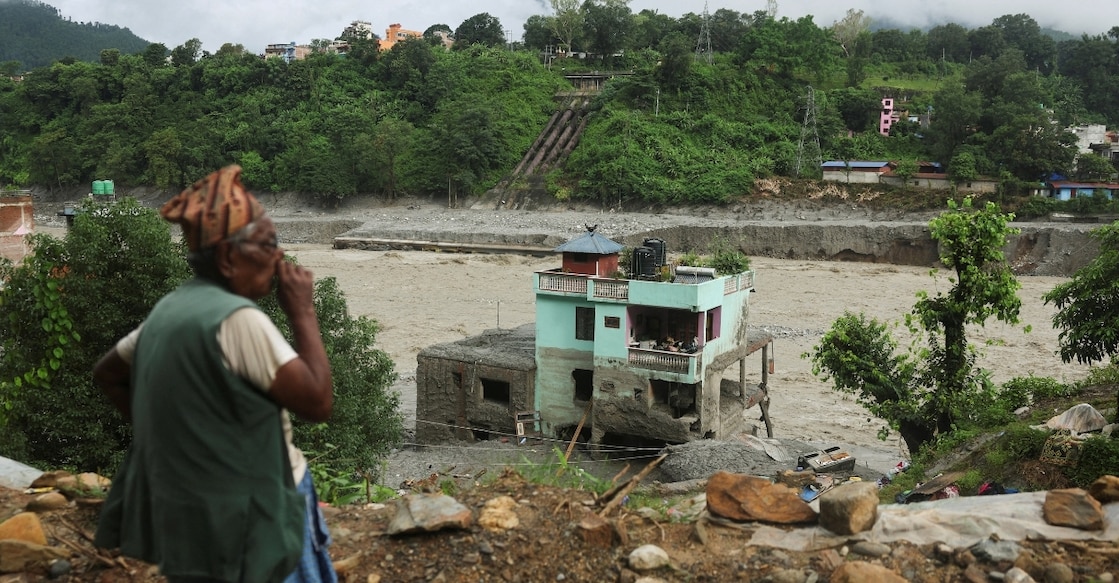 A man looks at the "green miracle house" as it stands amid debris after surviving flash floods and a mudslide in Nuwakot district of Nepal. Photo: Reuters