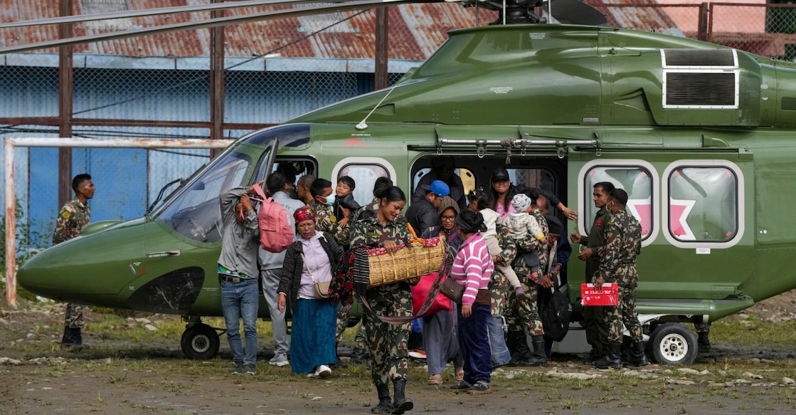 A Nepal army official carries a baby rescued during a search and rescue operation after the devastating flash floods in Rasuwa. Photo: PTI