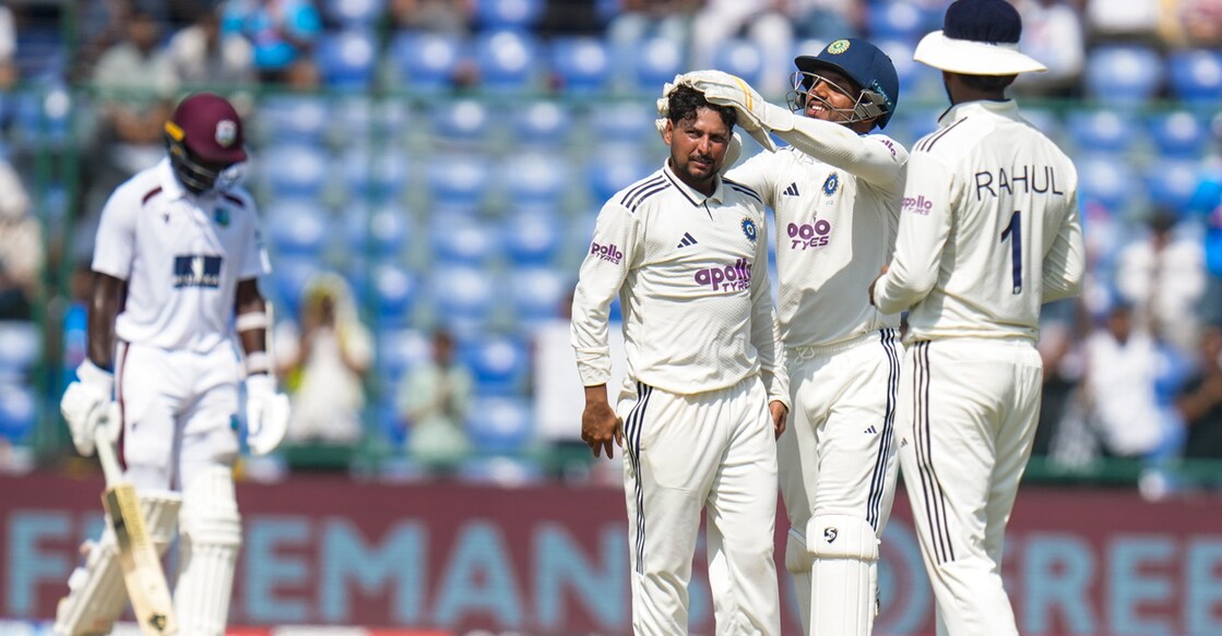 India's Kuldeep Yadav with his teammates after taking the wicket of West Indies' Jayden Seales to complete his five-wicket haul on day three of the second and final Test in Delhi on October 12, 2025. Photo: PTI
