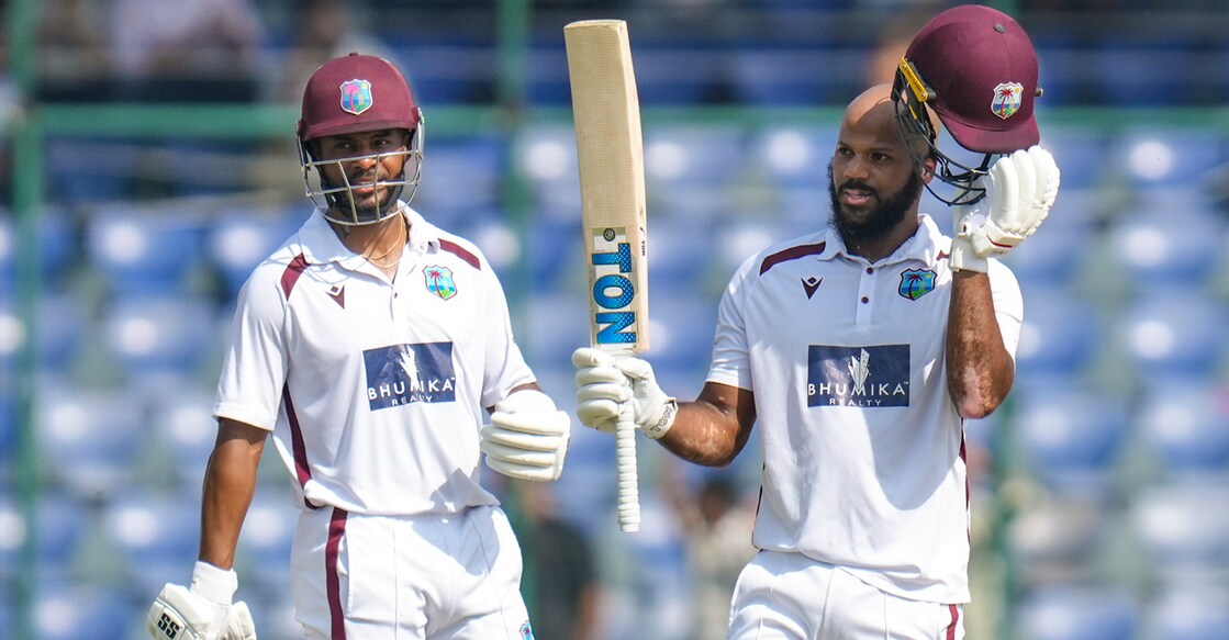 West Indies' John Campbell celebrates his century as Shai Hope looks on during the 4th day of the second Test against India in Delhi on October 13, 2025. Photo: PTI