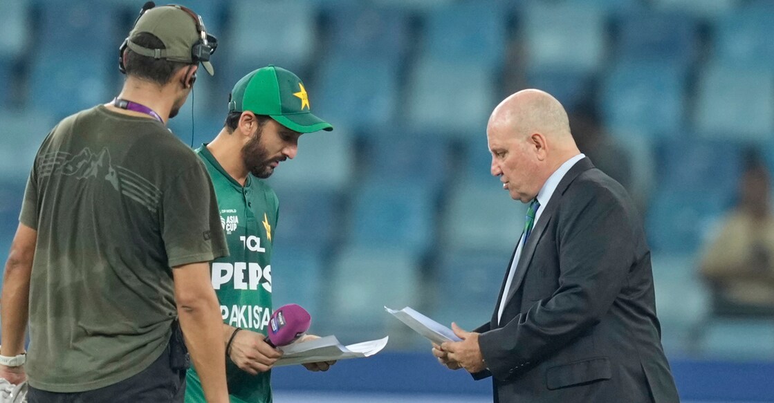 Pakistan's captain Salman Agha shares the team list with match referee Andy Pycroft at the toss during the Asia Cup cricket match against the UAE at Dubai International Cricket Stadium on September 17, 2025. Photo: PTI