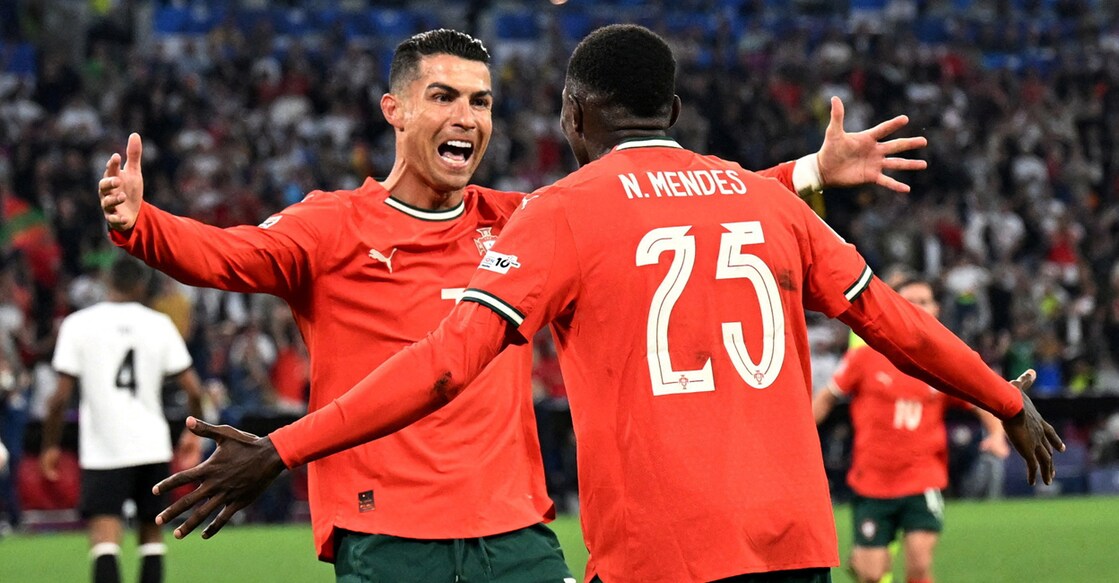 Cristiano Ronaldo celebrates scoring their second goal with Portugal's Nuno Mendes. Photo: REUTERS/Angelika Warmuth