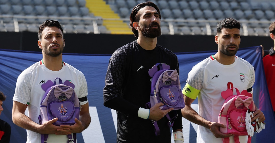 Iran's Shoja Khalilzadeh, Alireza Beiranvand and Mehdi Taremi hold school bags in memory of the victims of the girls' school bombing in Minab. Photo: Reuters/Umit Bektas