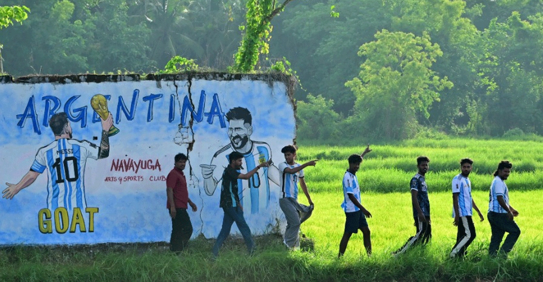 Fans of World Champions Argentina in Palakkad walk in front of a graffiti of Lionel Messi made for the World Cup. Photo: Manorama