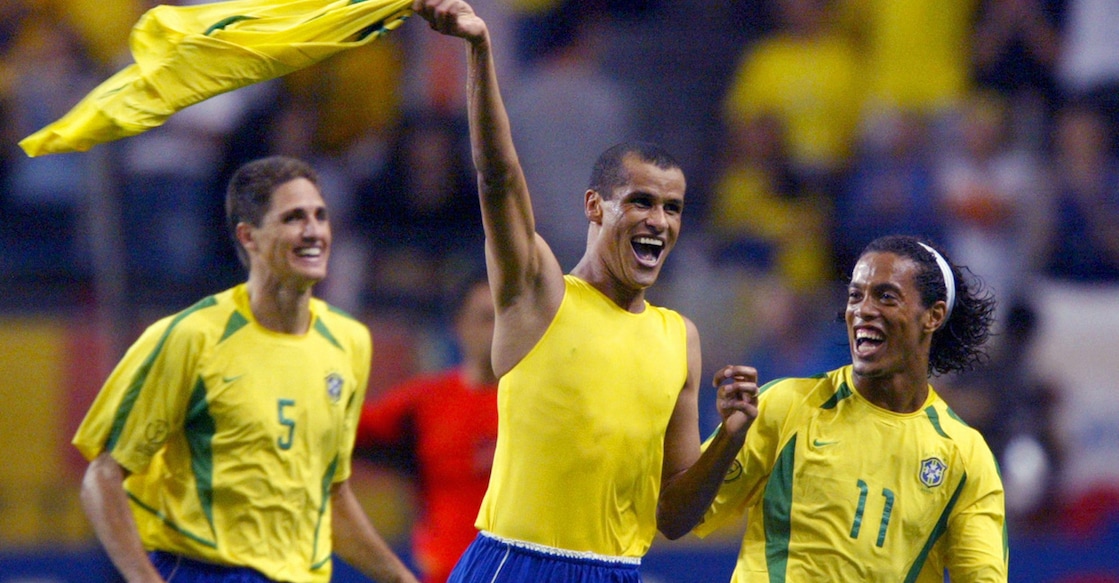 Brazilian midfielder Rivaldo (C) celebrates after scoring as Brazilian midfielder Ronaldinho (R) and Brazilian defender Edmilson look on during the second round match Brazil/Belgium of the 2002 FIFA World Cup in Korea and Japan, 17 June 2002 at Kobe Wing Stadium.  AFP PHOTO ANTONIO SCORZA (Photo by ANTONIO SCORZA / AFP)