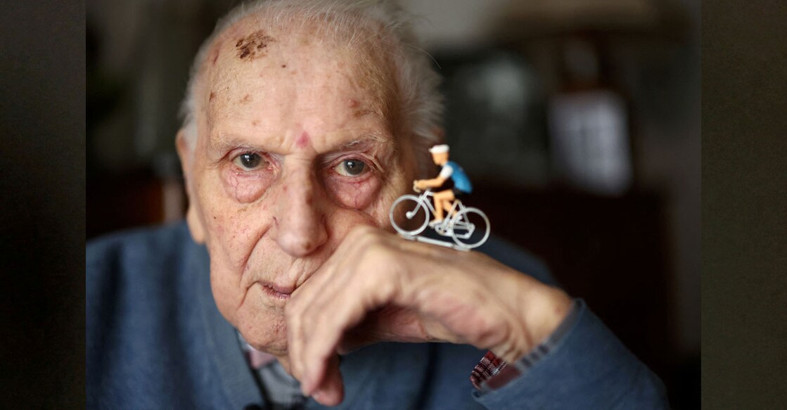 Charles Coste poses with a cyclist figurine during an interview at his apartment in Bois-Colombes, near Paris, France, February 5, 2024. Photo: REUTERS/Stephanie Lecocq