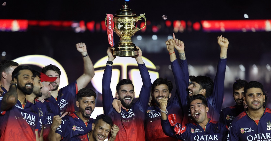 CRICKET-IPL-RCB-PBKS Royal Challengers Bengaluru's Virat Kohli lifts the IPL trophy as he celebrates with his teammates. Photo: Reuters/Amit Dave