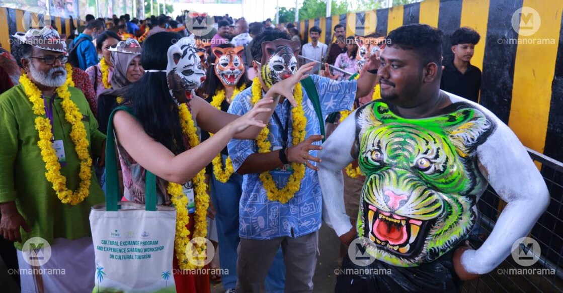 A tourist interacts with a Pulikali artiste. Photo: Special Arrangement