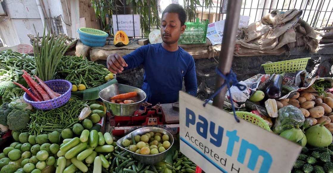 Food prices soar A vendor weighs vegetable next to an advertisement of Paytm, a digital payments firm, hanging amidst his vegetables at a roadside market in Mumbai, India, April 2, 2019. REUTERS/Francis Mascarenhas/File Photo
