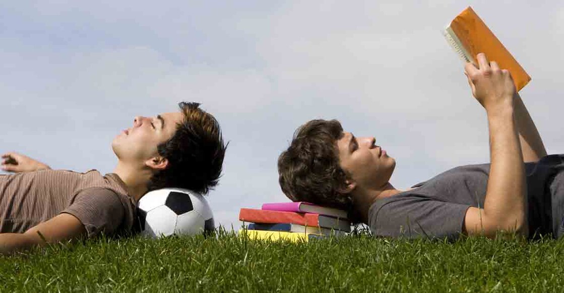 Two young students lying on the grass