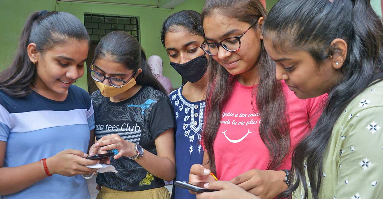 DU cut-offs likely to be higher as more students score above 95% in Class 12 exams Students while checking their marks after UP Board declared its 12th class results in Ghaziabad. PTI