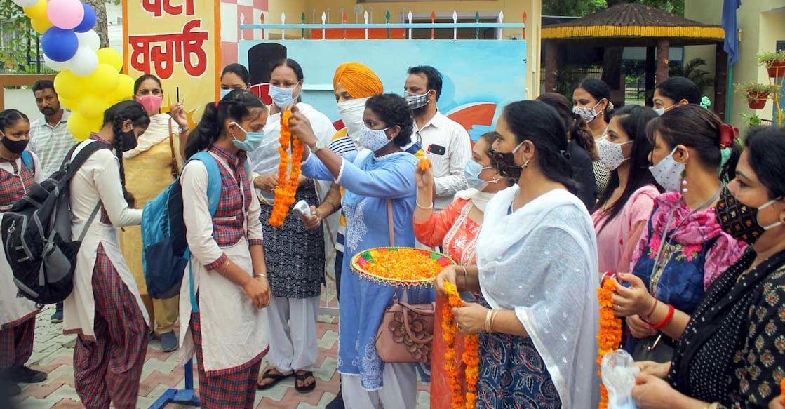 Students being welcomed at Government Girls Senior Secondary Smart School after it reopened, following relaxation in COVID-19 norms in Patiala. PTI