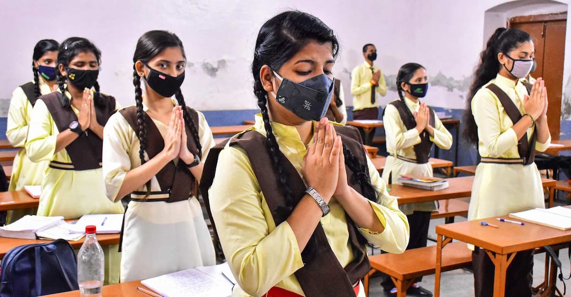 Students wearing face masks join a prayer in the classroom of a school that reopened after further ease in COVID-19 lockdown restrictions in Jabalpur. PTI