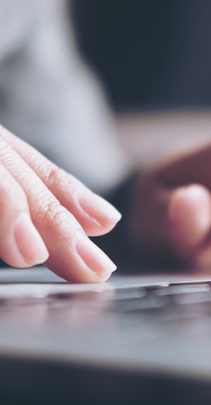 Application Closeup image of a business woman's hands working and typing on laptop keyboard on glass table