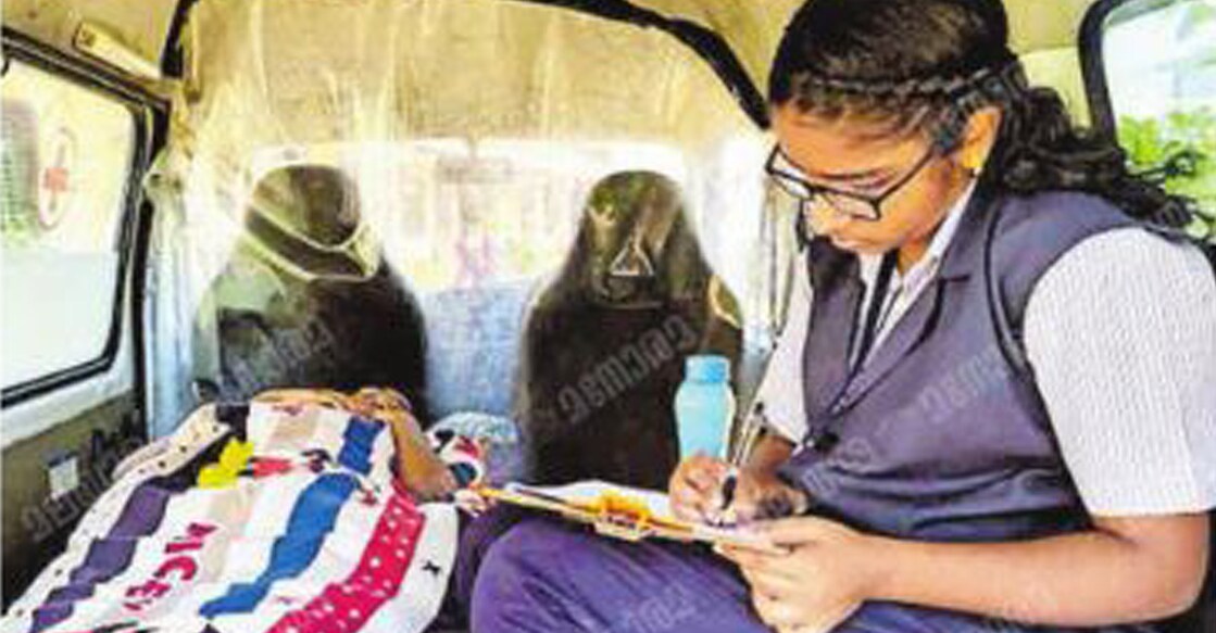 ambulance-student-main Aggie Theresa, daughter of a teacher at the Sacred Heart School, writing down the answers dictated by Ann Mary while she lay on a stretcher. Photo: Manorama