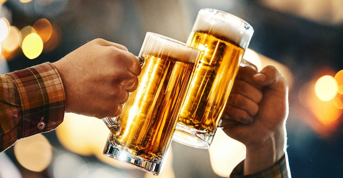 Two glasses of beer in cheers gesture. Photo: iStock/gilaxia
