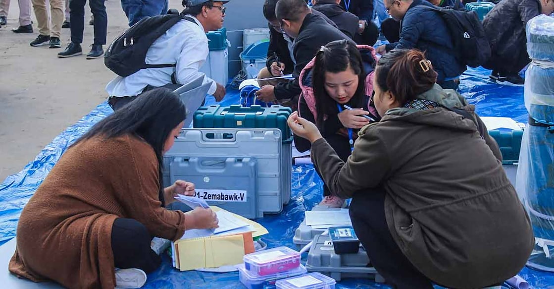 Polling officials collect EVMs and other election material at a distribution centre ahead of voting for Mizoram Assembly elections. Photo: PTI