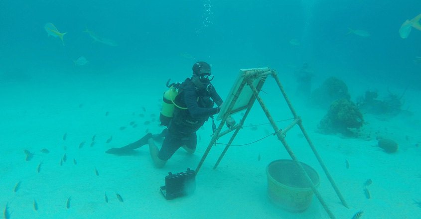 Cuban artist sketches under the sea among fish and coral reefs Cuban artist sketches under the sea among fish and coral reefs