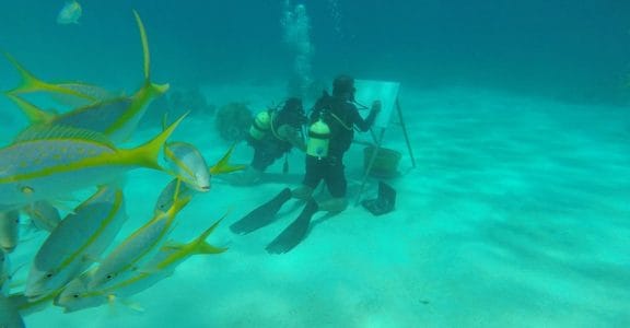 Cuban artist sketches under the sea among fish and coral reefs Cuban artist sketches under the sea among fish and coral reefs