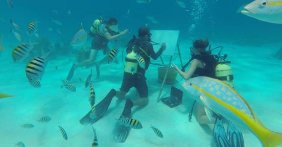Cuban artist sketches under the sea among fish and coral reefs Cuban artist sketches under the sea among fish and coral reefs