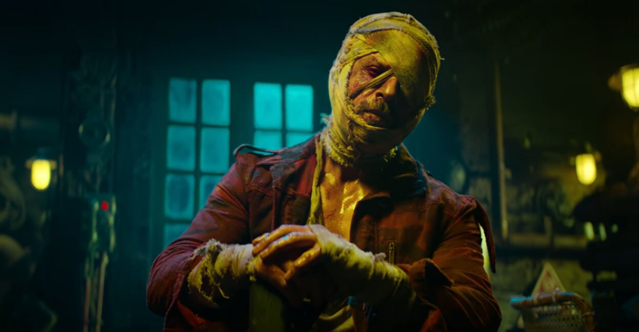 The teaser of 'Jawan' shows SRK walking into a room armed with a gun and a bandage covering his head. Photo: YouTube