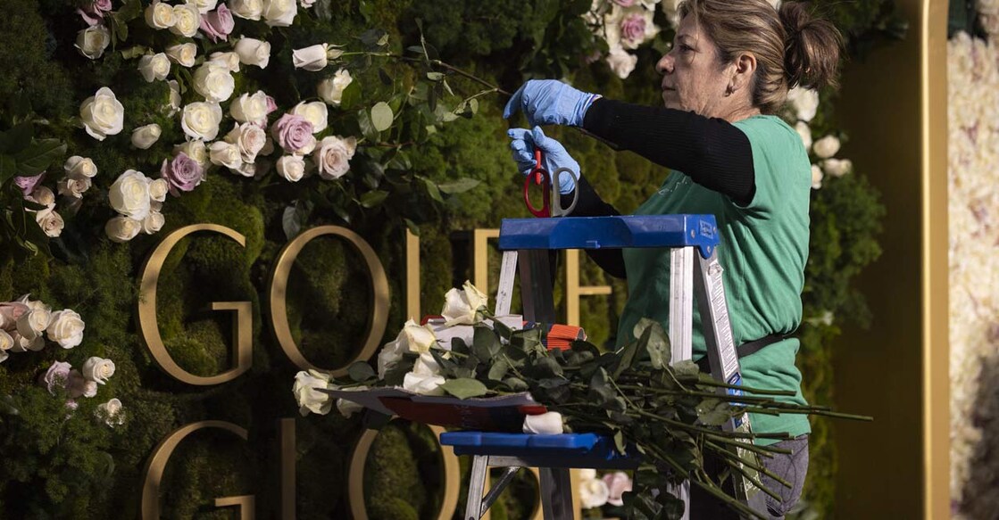 A florist places fresh roses on the backdrop of the red carpet as technicians and workers add the last touches the day before the Golden Globes at Beverly Hilton in Beverly Hills, California. Photo: AFP/ ETIENNE LAURENT