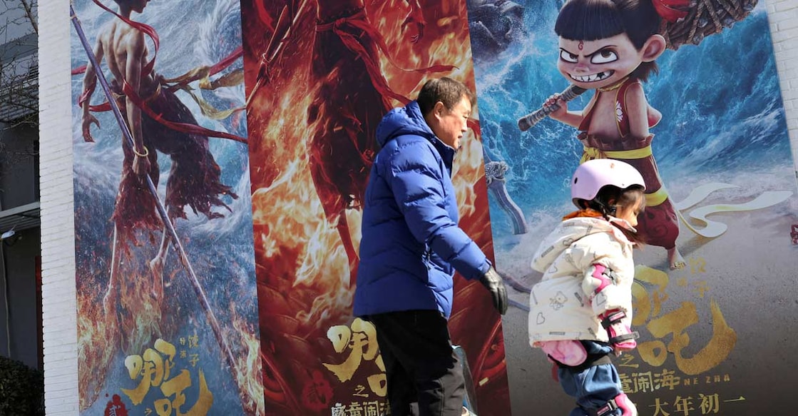 A child skates past promotional posters for the Chinese movie 'Ne Zha 2' outside the office of a film production company in Beijing, China. Reuters/Florence Lo