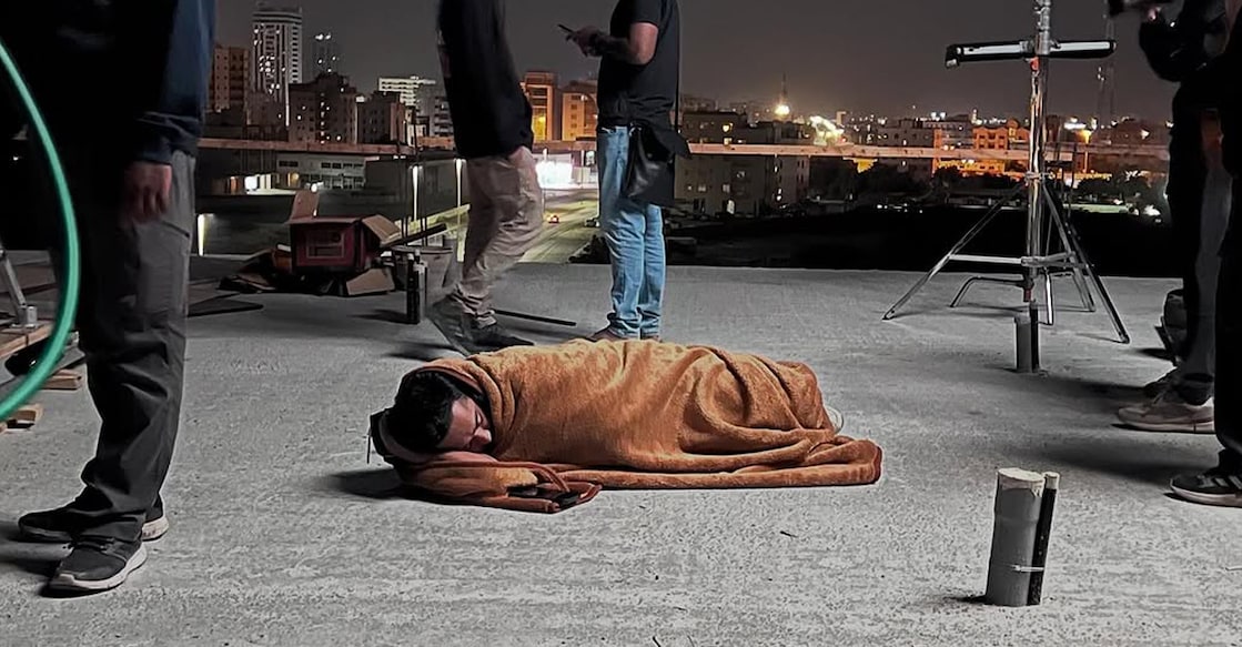 asif-ali-sarkeet In the behind-the-scenes photo, Asif Ali is seen lying on the ground, wrapped in a thin blanket, resting between takes during a night shoot. Photo: Instagram