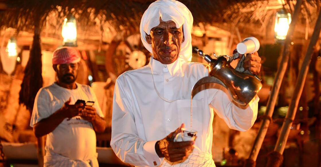 Qahwa is being poured from a traditional coffee pot (dallah) to a mug. Photo: Jayan Orma