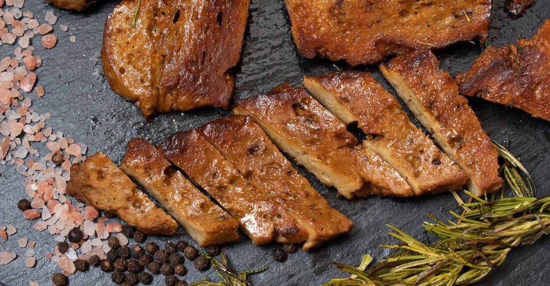 Roasted seitan steaks with herbs and spices on slate plate. Photo: iStock/Adela Srinivasan