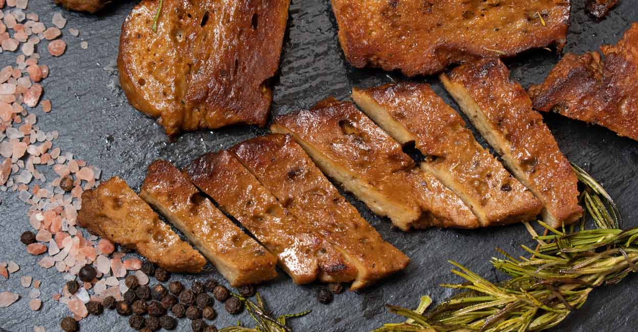 Roasted seitan steaks with herbs and spices on slate plate. Photo: iStock/Adela Srinivasan
