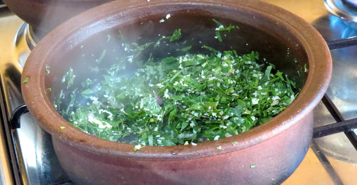 Green leaves being cooked on an earthen pot Representative image: iStock/DarshanaA